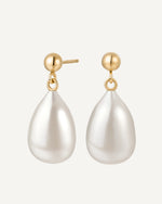 Pearl drop earrings with gold posts on a white background