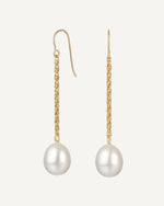 Gold earrings with pearl drops on a white background