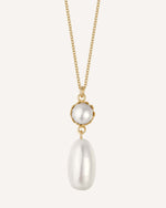 Gold necklace with two white pearls on a white background