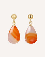 Pair of teardrop-shaped earrings with gold hooks on a white background