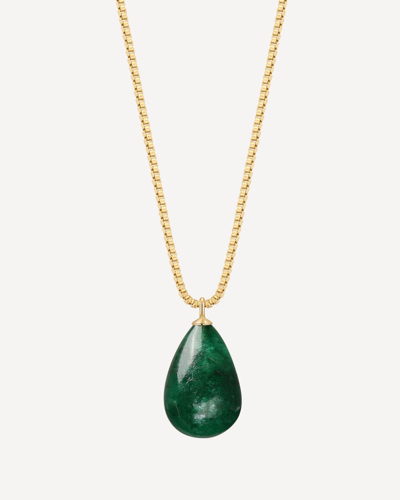 Gold necklace with a green teardrop pendant on a white background