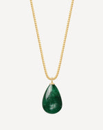 Gold necklace with a green teardrop pendant on a white background