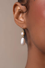 Pearl earring worn by a person with a neutral background