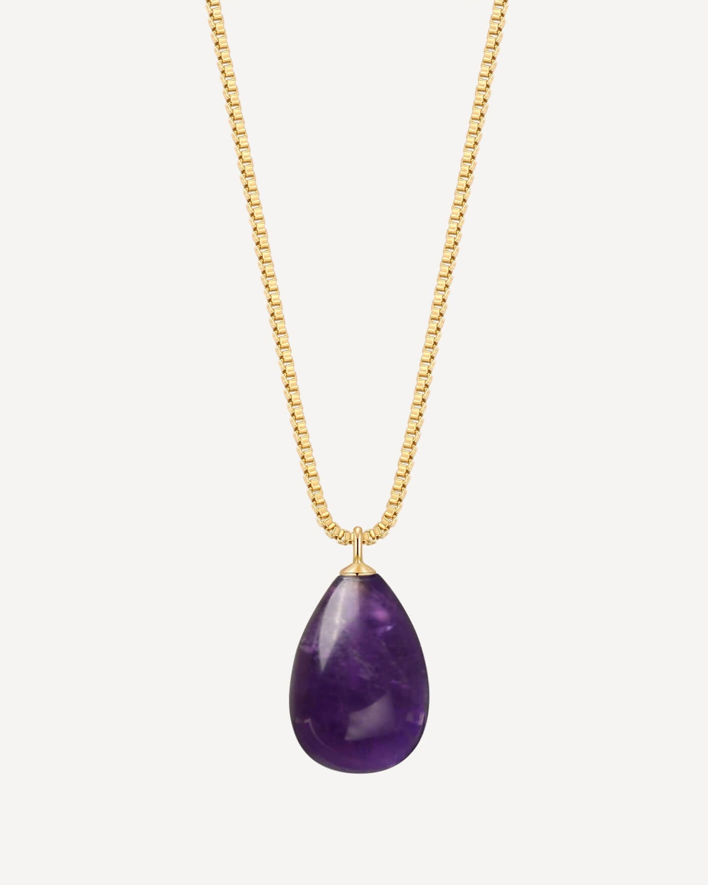 Gold necklace with a purple teardrop pendant on a white background