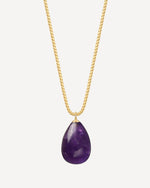 Gold necklace with a purple teardrop pendant on a white background