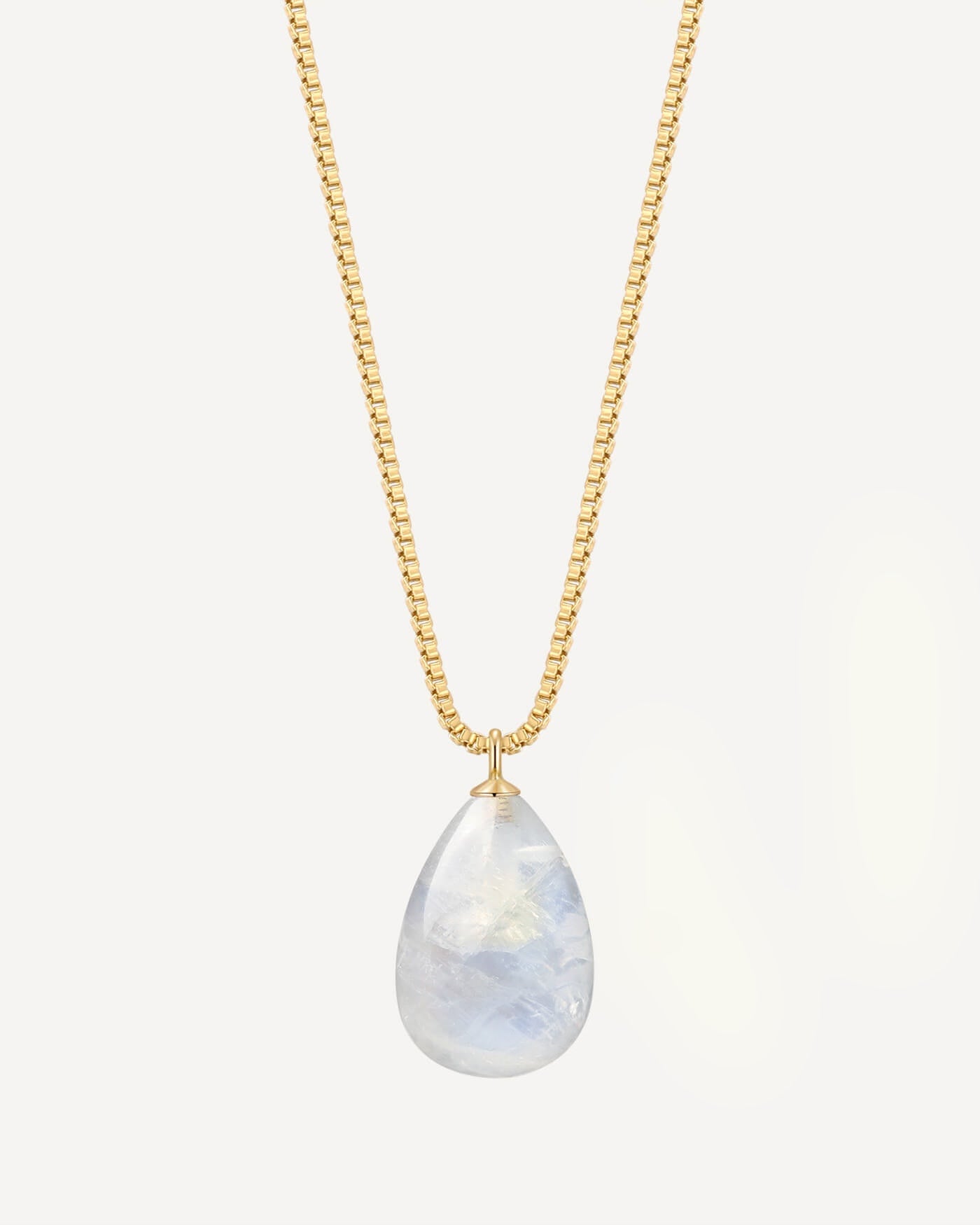 Gold necklace with a teardrop-shaped blue lace agate pendant on a light gray background
