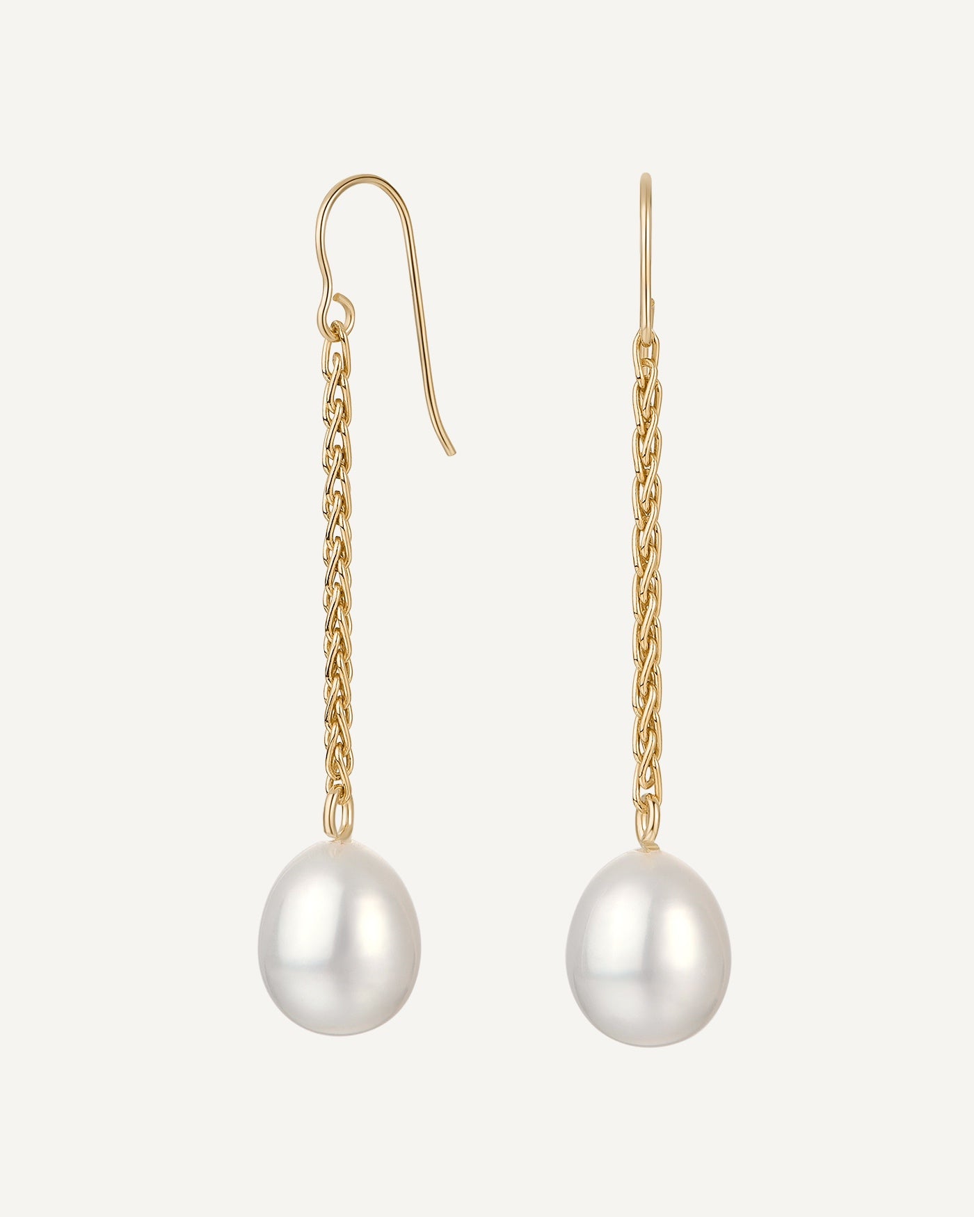 Gold earrings with pearl drops on a white background