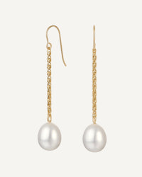 Gold earrings with pearl drops on a white background
