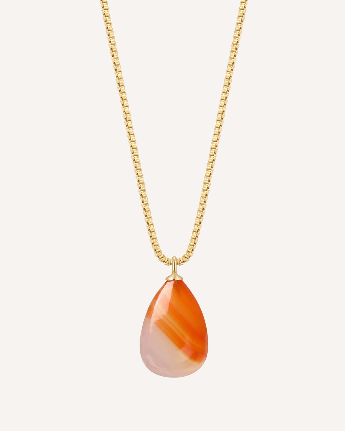 Necklace with a teardrop-shaped orange and white pendant on a gold chain against a white background