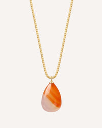 Necklace with a teardrop-shaped orange and white pendant on a gold chain against a white background