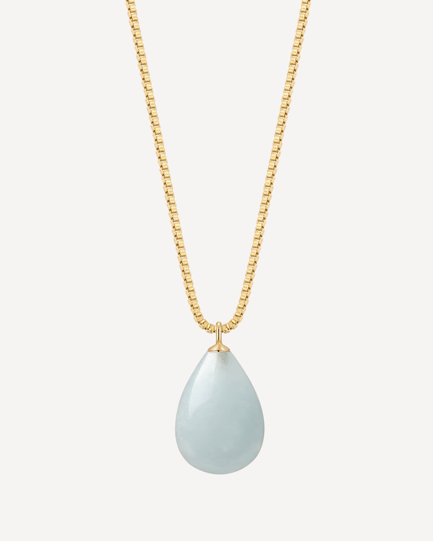 Gold necklace with a teardrop-shaped light blue pendant on a white background
