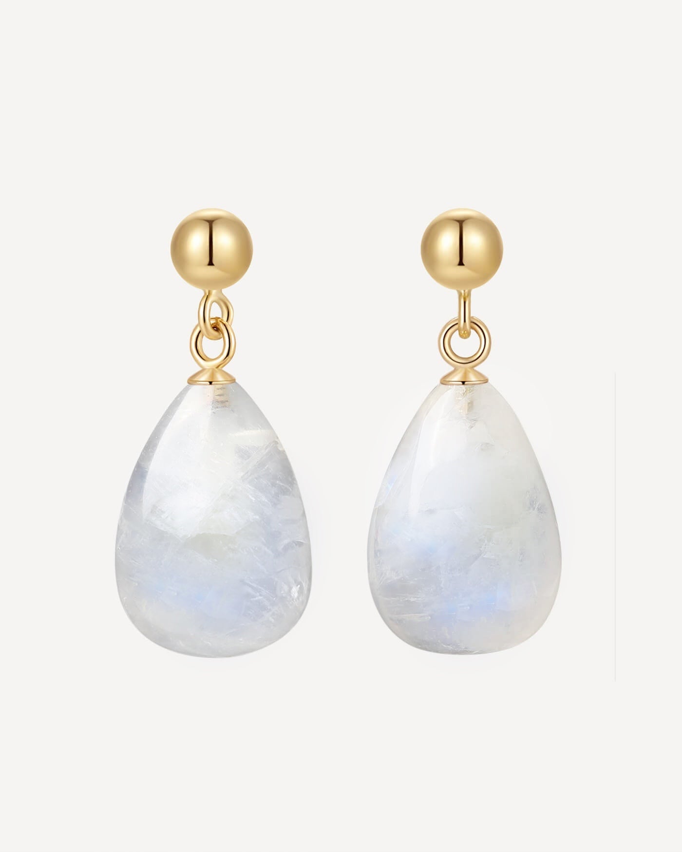 Gold earrings with teardrop-shaped moonstone stones on a white background