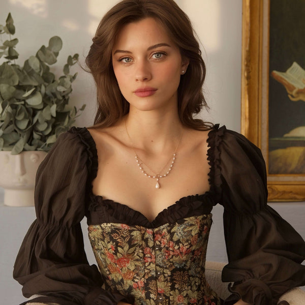 Woman wearing a vintage-style dress with intricate details, sitting indoors.