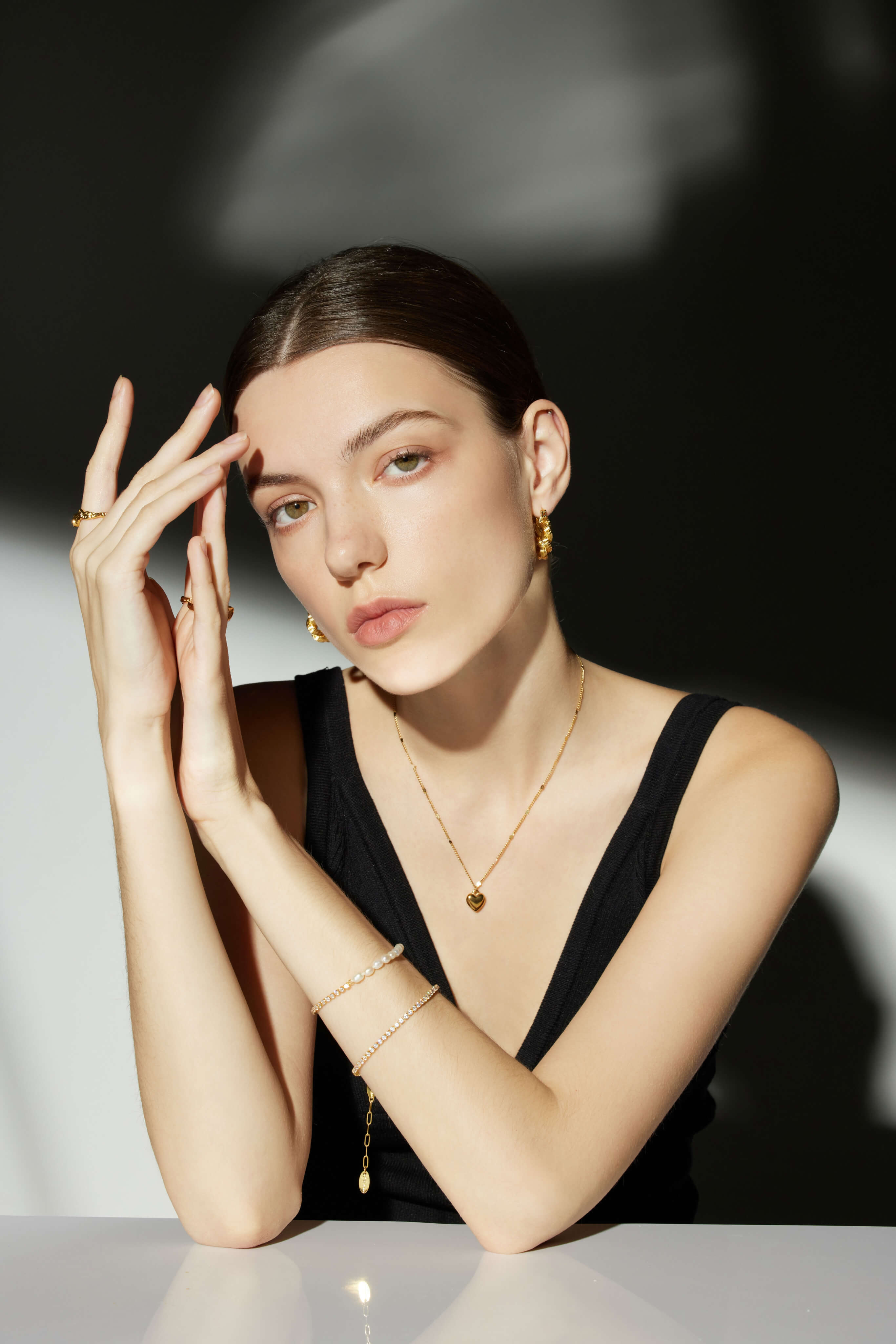 Woman wearing gold jewelry against a neutral background