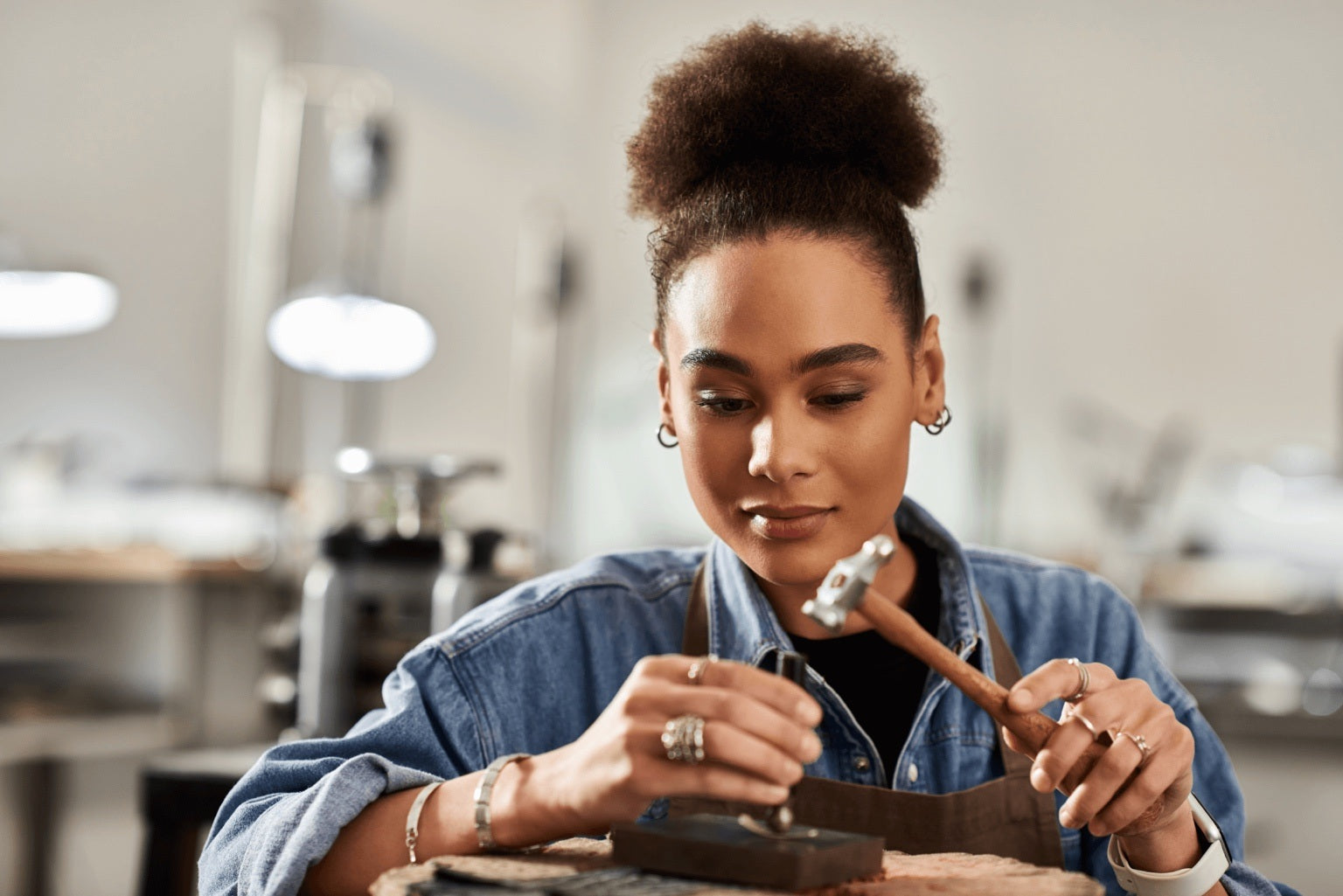 Woman working with jewelry in a workshop setting